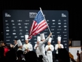 Bradley-waving-flag-with-JeromeBocuse-EmerilLagsse-JeffreyHayashi-GavinKaysen-clapping-TeamUSA_NOLA-532-photocredit_KenGoodman